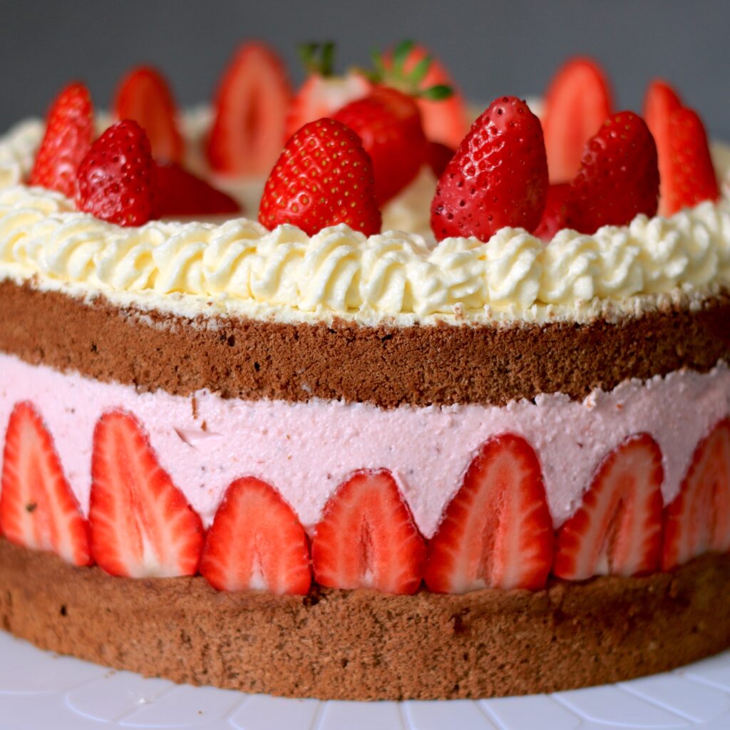 Eine Erdebeertorte aus mehreren Ebenen mit Erbeerkrone.